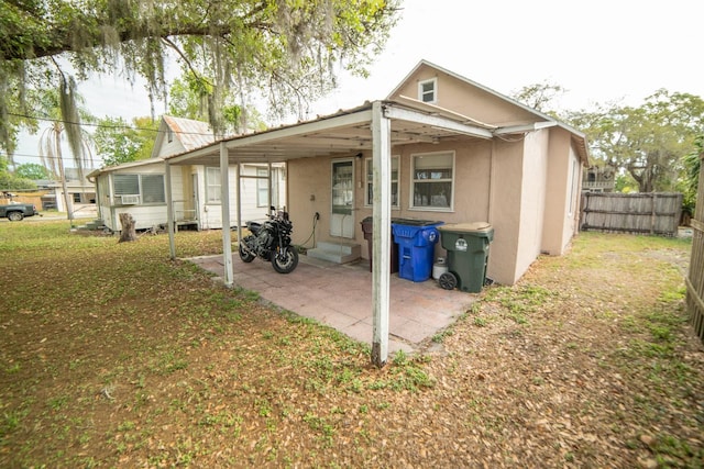 back of house featuring a lawn and a carport