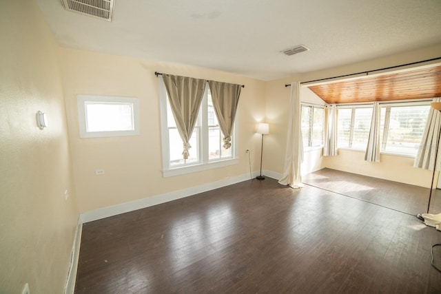 unfurnished room featuring dark hardwood / wood-style flooring and vaulted ceiling