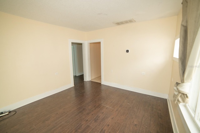 empty room featuring dark wood-type flooring