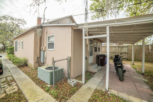 view of side of home featuring a carport and central AC