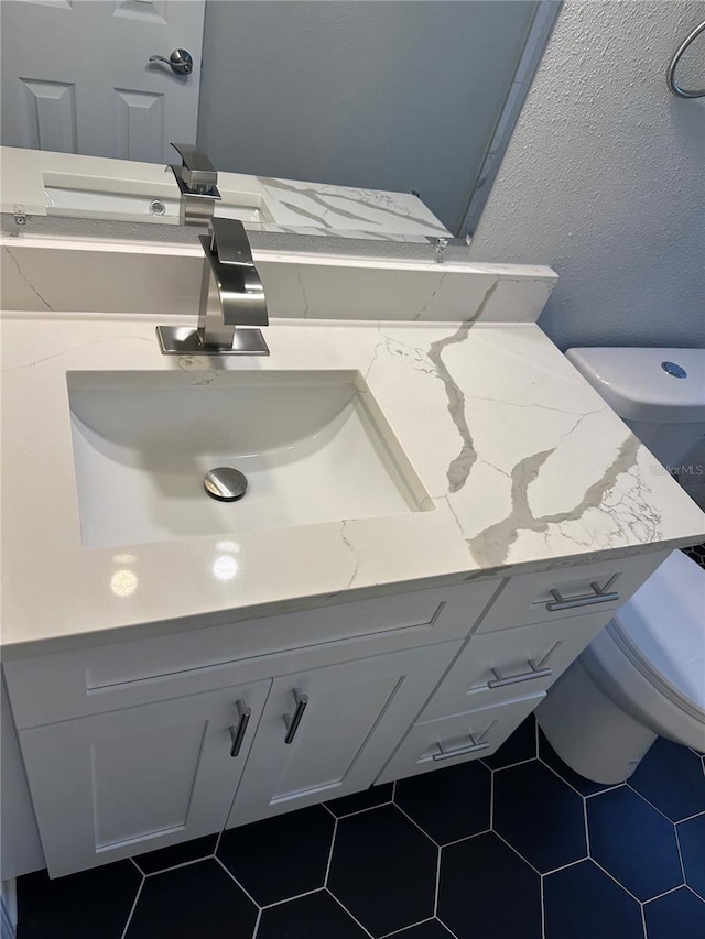 bathroom with vanity, toilet, and tile patterned floors