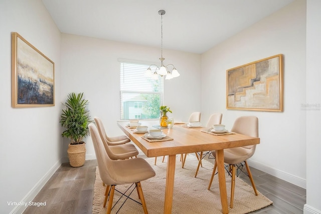 dining area with hardwood / wood-style flooring and a notable chandelier