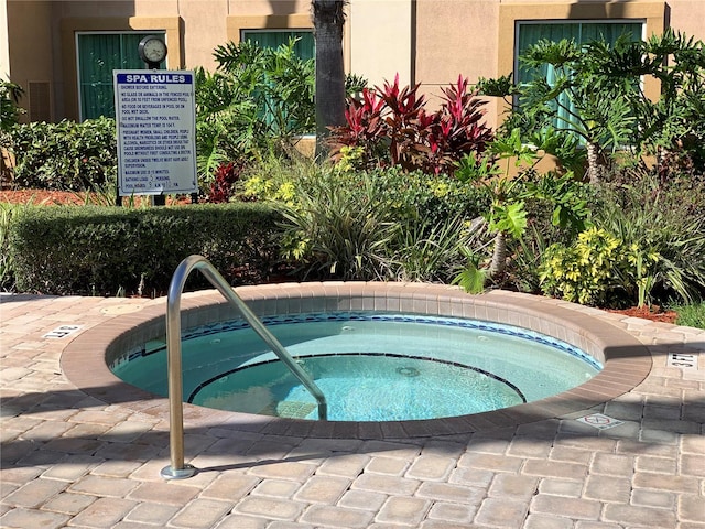 view of pool with a hot tub