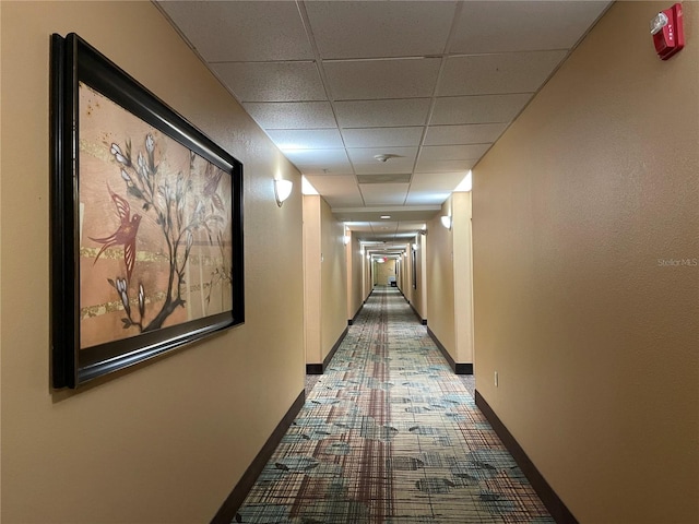 corridor with a paneled ceiling