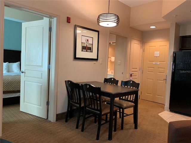 dining space featuring light carpet