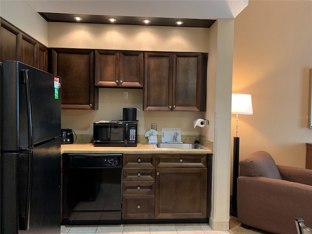 kitchen featuring sink, dark brown cabinets, black appliances, and light tile floors