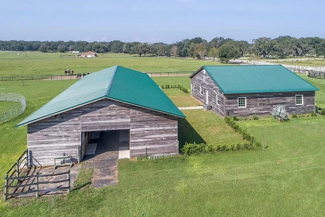 exterior space featuring an outdoor structure, a yard, and a rural view