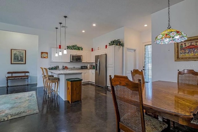 dining space featuring a textured ceiling and a high ceiling