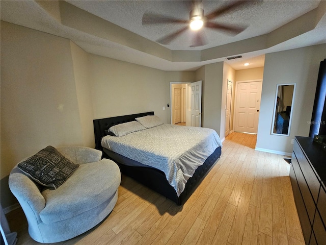 bedroom featuring a textured ceiling, light wood-type flooring, and ceiling fan