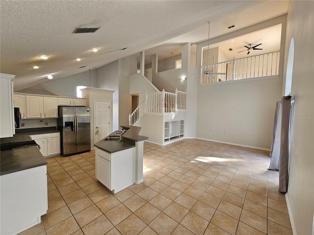 kitchen featuring light tile patterned flooring, sink, stainless steel fridge, ceiling fan, and white cabinets