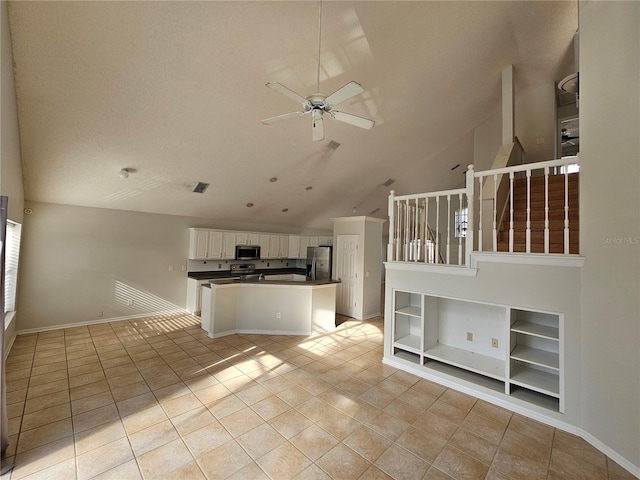 kitchen featuring built in shelves, lofted ceiling, ceiling fan, stainless steel appliances, and white cabinets