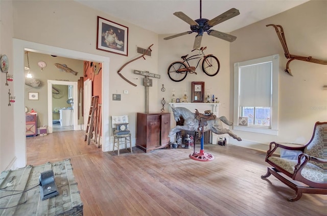 living area featuring high vaulted ceiling, ceiling fan, and wood-type flooring