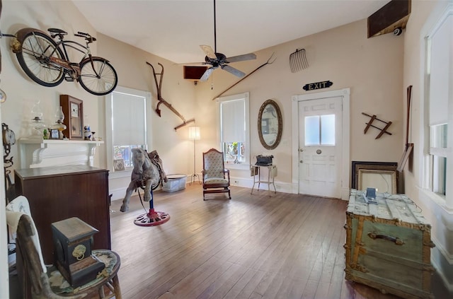 living area with a healthy amount of sunlight, ceiling fan, and hardwood / wood-style floors