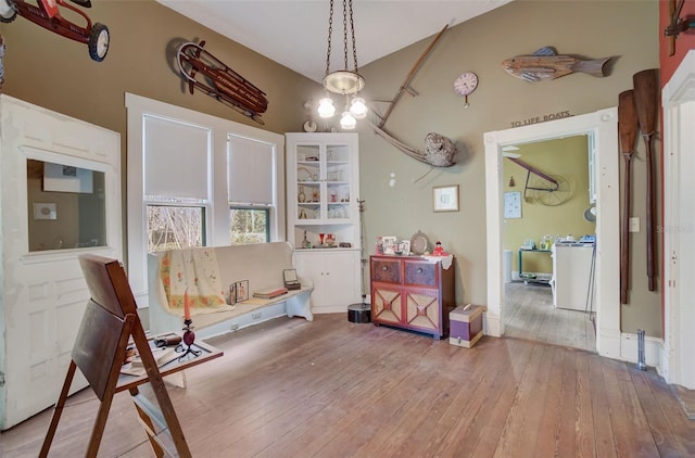 sitting room with high vaulted ceiling and hardwood / wood-style flooring