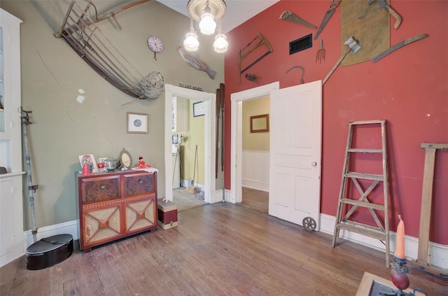 miscellaneous room featuring hardwood / wood-style floors and a high ceiling