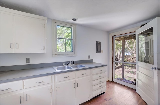 kitchen with a healthy amount of sunlight, sink, white cabinets, and dark hardwood / wood-style flooring