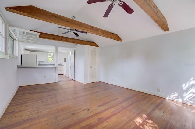 unfurnished living room featuring lofted ceiling with beams, hardwood / wood-style flooring, and ceiling fan