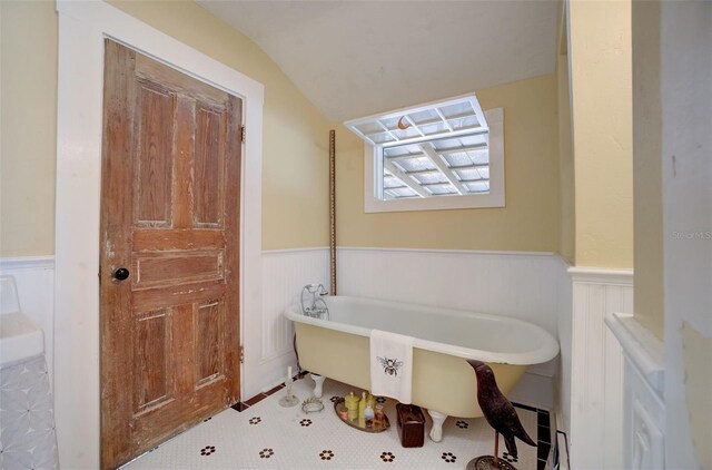 bathroom with lofted ceiling and a bathing tub