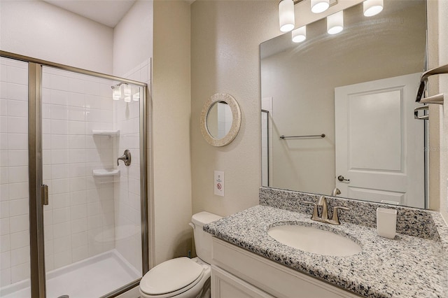 bathroom featuring toilet, a shower with shower door, and oversized vanity