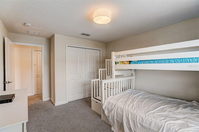 carpeted bedroom featuring a closet and a textured ceiling