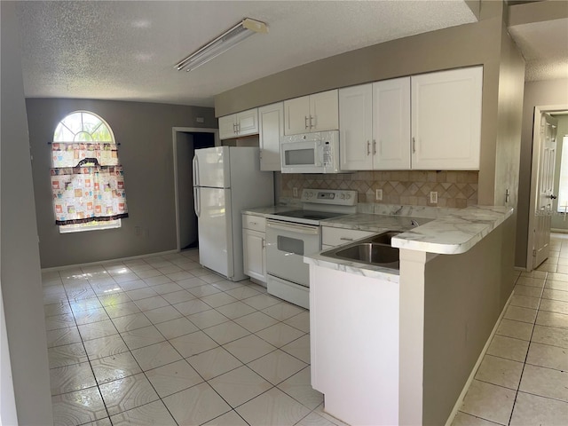 kitchen featuring white appliances, sink, light tile floors, tasteful backsplash, and white cabinetry