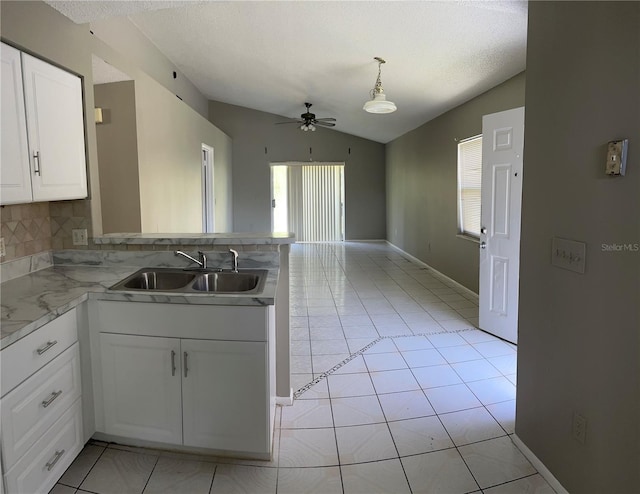 kitchen with vaulted ceiling, ceiling fan, tasteful backsplash, white cabinets, and sink