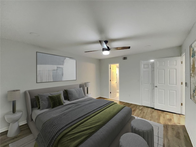 bedroom featuring connected bathroom, ceiling fan, and light hardwood / wood-style flooring