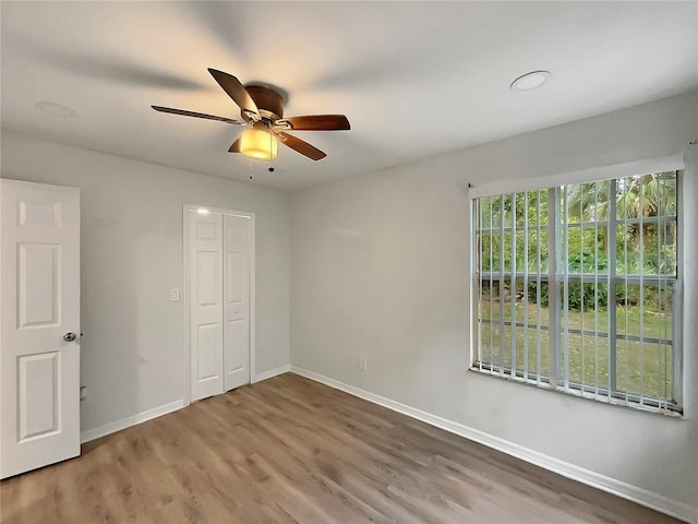 unfurnished bedroom with a closet, ceiling fan, and dark wood-type flooring