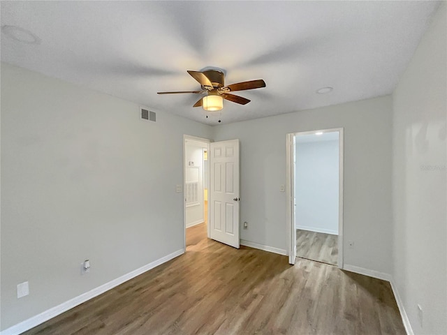 unfurnished bedroom with ceiling fan and wood-type flooring