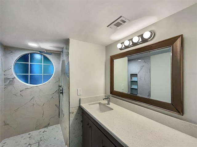 bathroom with large vanity and tiled shower