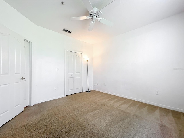 unfurnished bedroom with light carpet, a closet, and ceiling fan