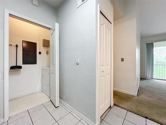 hall with washer and clothes dryer and light tile floors