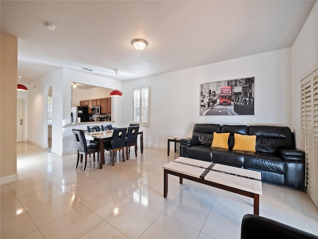 living room with light tile patterned floors and a textured ceiling