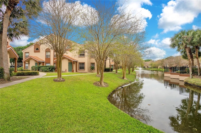 view of property's community with a water view and a yard