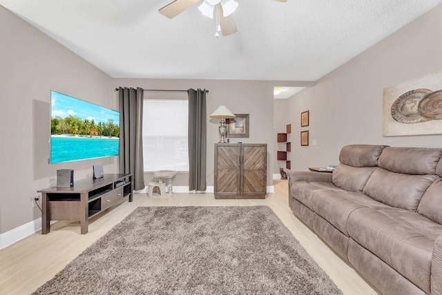 living room with a textured ceiling and ceiling fan