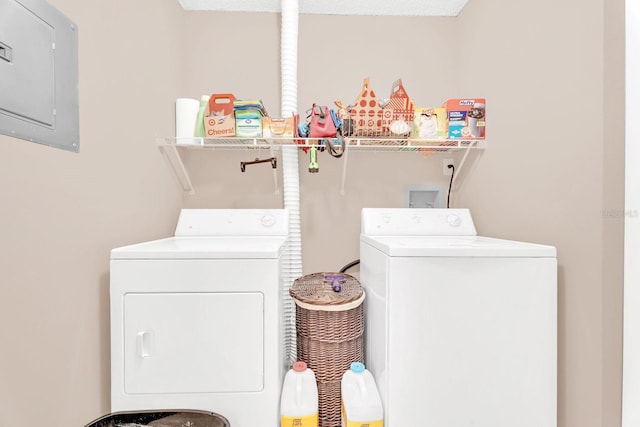 clothes washing area featuring electric panel and washing machine and dryer