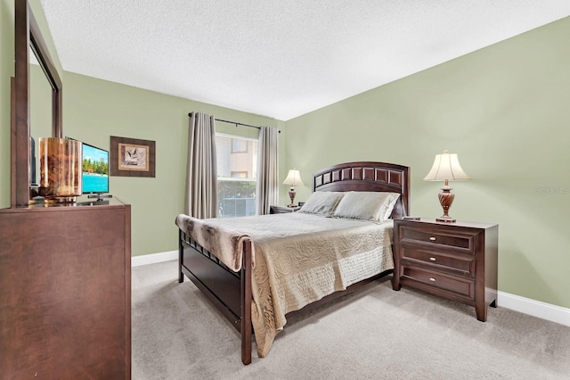 bedroom with light carpet and a textured ceiling