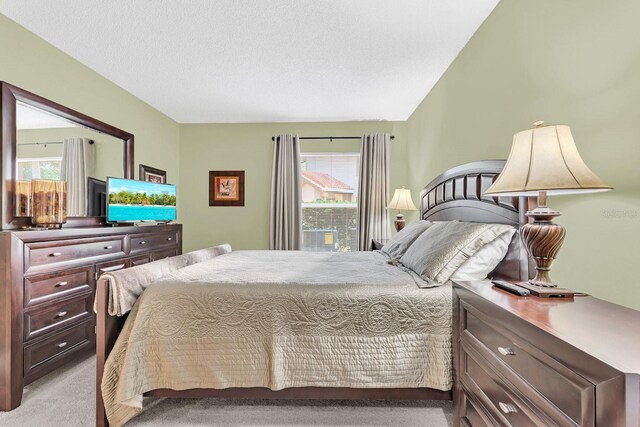 bedroom featuring light colored carpet and a textured ceiling