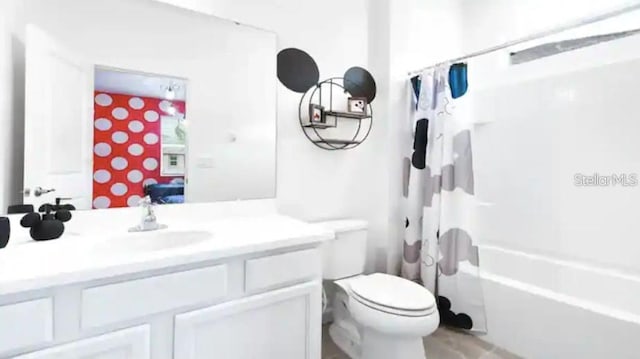 full bathroom featuring vanity, shower / bath combination with curtain, and toilet