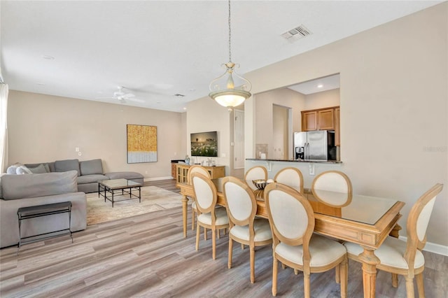 dining area with light hardwood / wood-style floors and ceiling fan