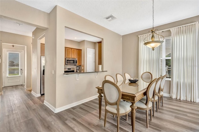 dining room featuring a textured ceiling and hardwood / wood-style floors