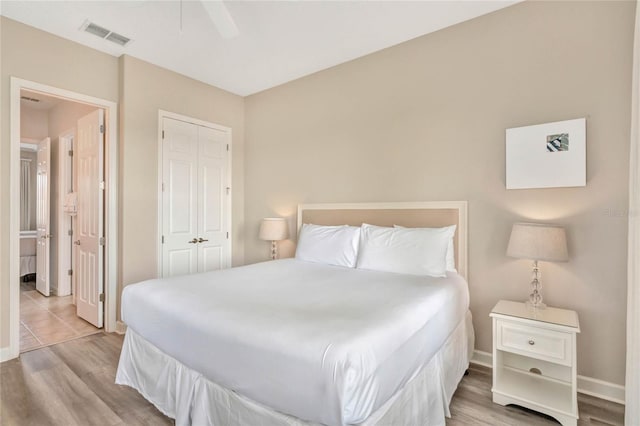 bedroom featuring a closet, light wood-type flooring, and ceiling fan