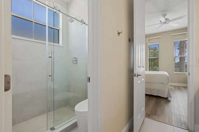 bathroom featuring toilet, hardwood / wood-style flooring, walk in shower, and ceiling fan