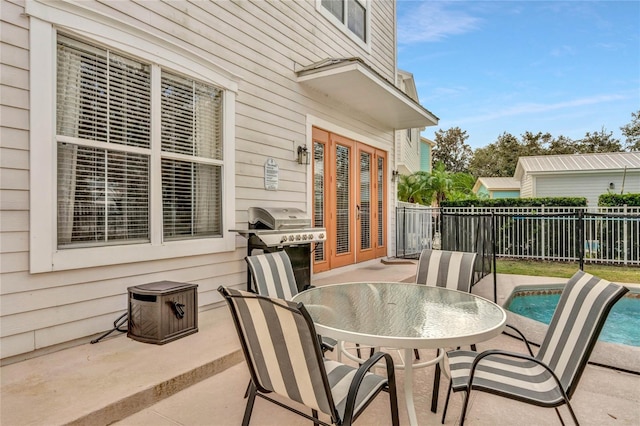 view of patio with french doors, area for grilling, and a fenced in pool