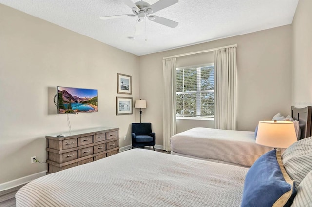 bedroom with hardwood / wood-style floors, a textured ceiling, and ceiling fan