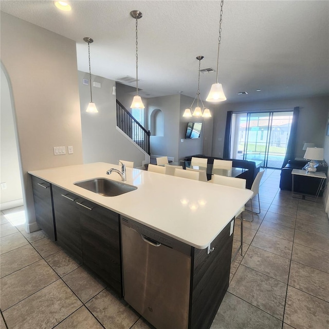 kitchen featuring hanging light fixtures, a notable chandelier, sink, a center island with sink, and stainless steel dishwasher