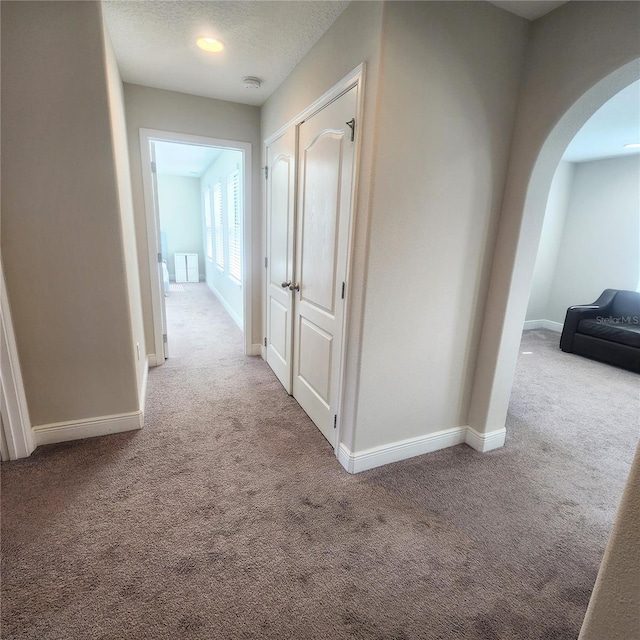 hall with light colored carpet