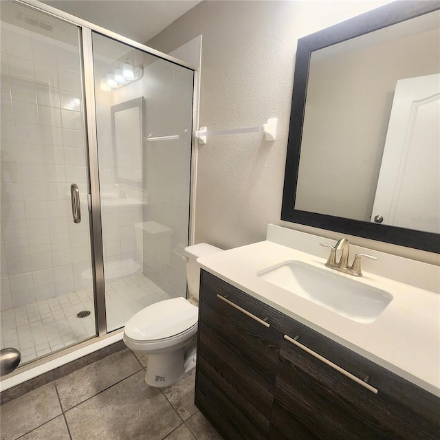 bathroom featuring an enclosed shower, tile floors, vanity with extensive cabinet space, and toilet