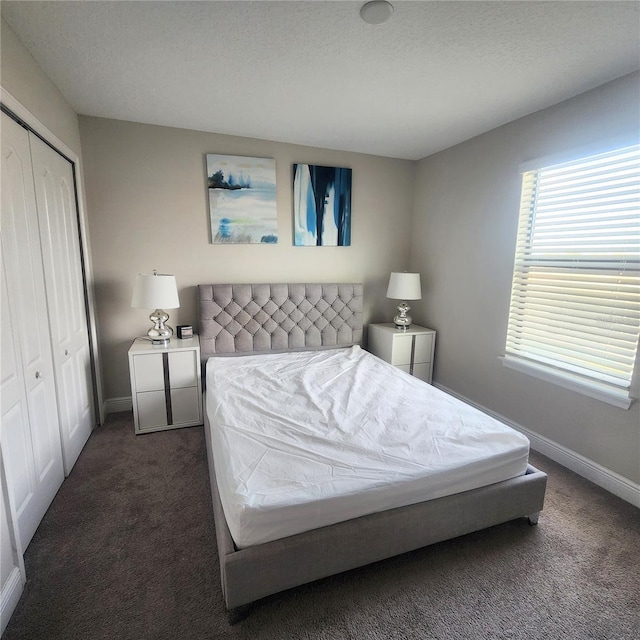 bedroom with a closet and dark colored carpet