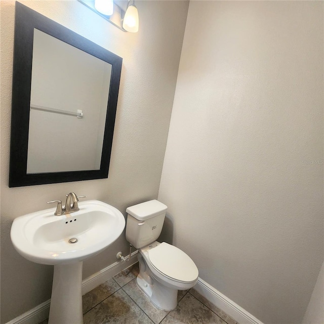 bathroom featuring toilet and tile floors